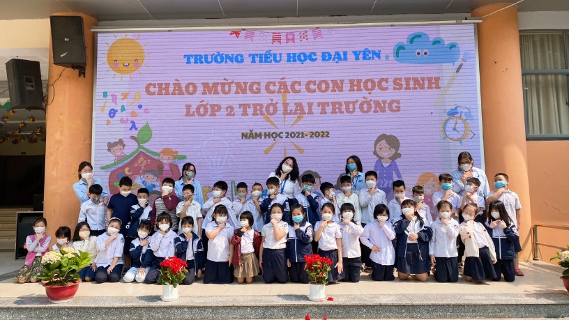 A group of children posing for a photo in front of a large screen
Description automatically generated with medium confidence