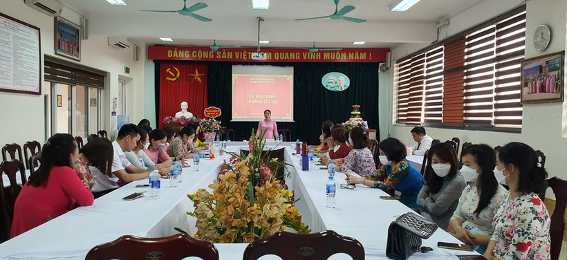 A group of people sitting at long tables in a room with a screen
Description automatically generated with low confidence