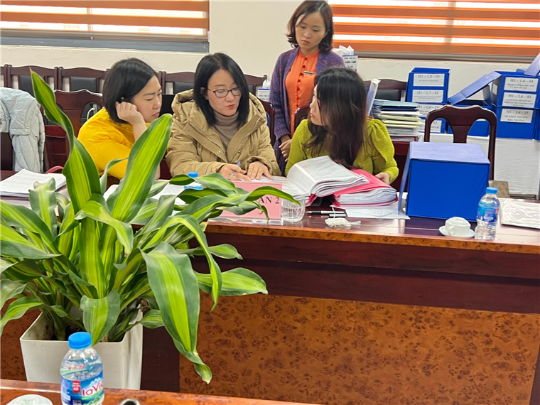 A group of women sitting at a desk
Description automatically generated
