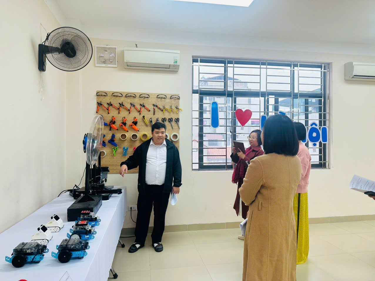 A group of people standing in a room
Description automatically generated