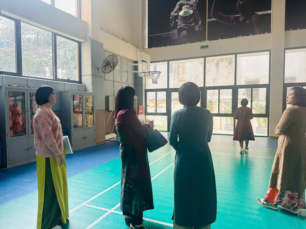 A group of people standing in a gym
Description automatically generated