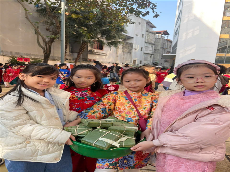 A group of girls holding a green bucket of food
Description automatically generated