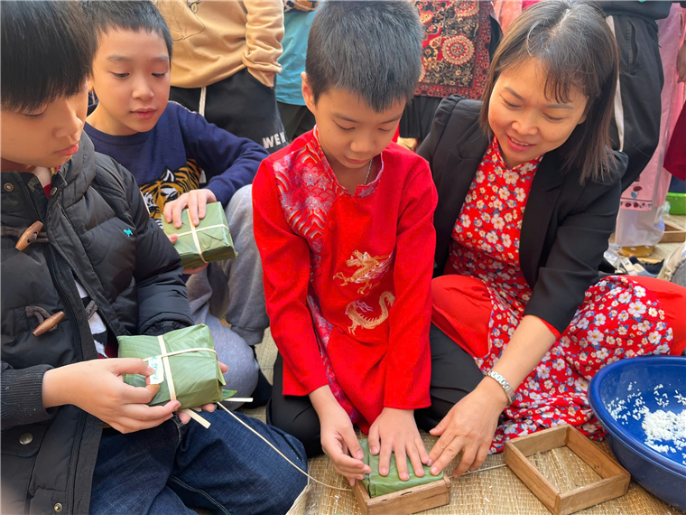 A group of people sitting on the ground
Description automatically generated