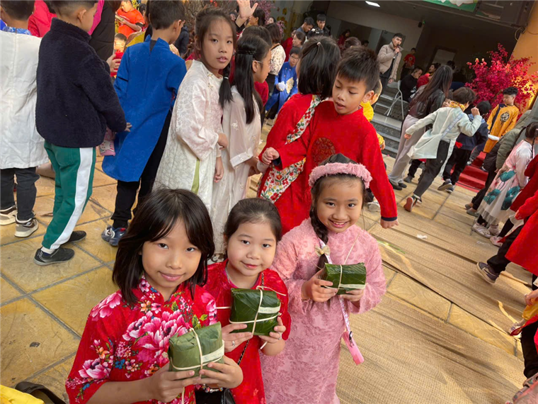 A group of children holding small green objects
Description automatically generated