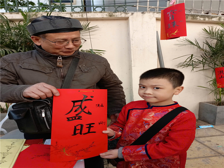 A person holding a red sign next to a child
Description automatically generated