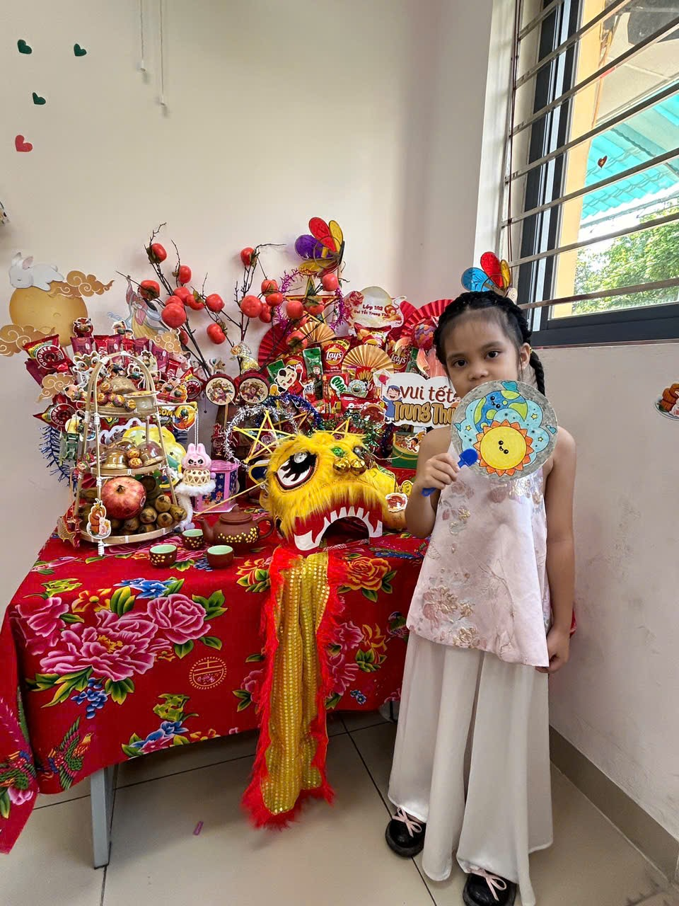 A child holding a fan in front of a table with decorations

AI-generated content may be incorrect.