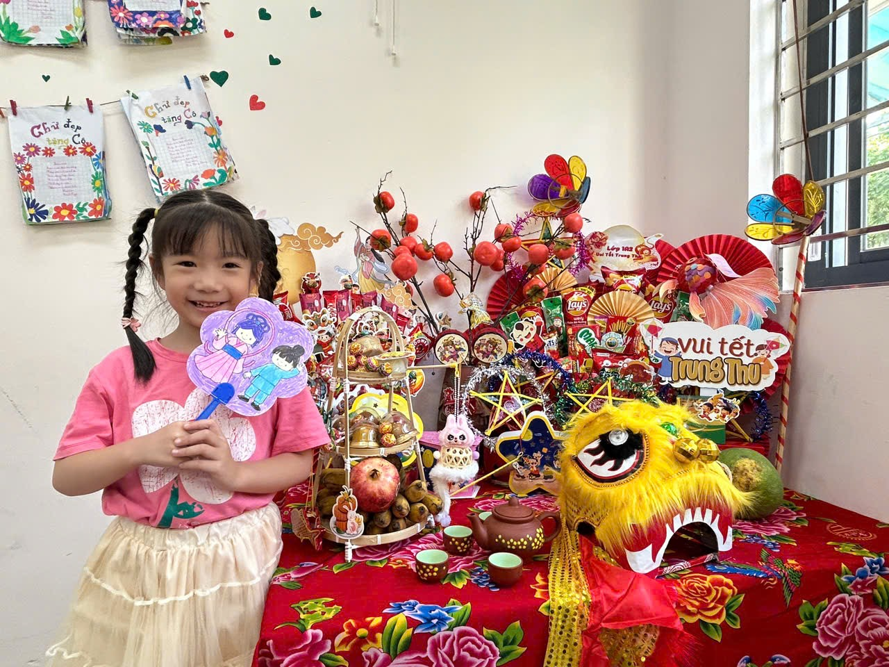 A child holding a fan in front of a table full of decorations
AI-generated content may be incorrect.