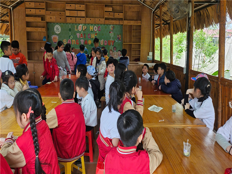 A group of children sitting at tables in a classroom

AI-generated content may be incorrect.