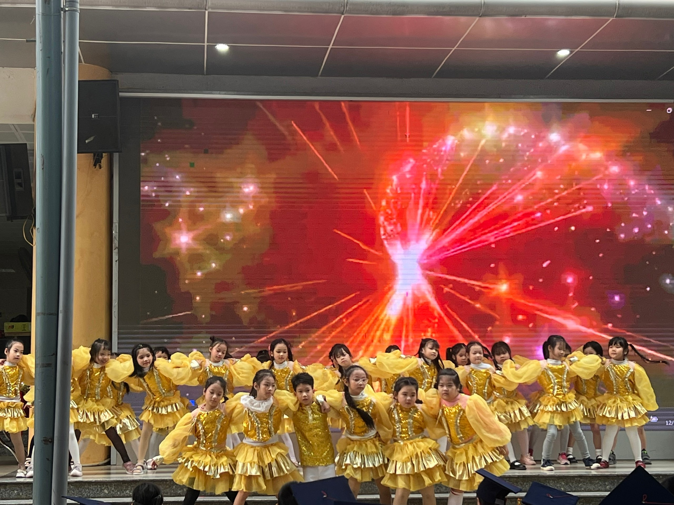 A group of children in yellow dresses on a stage

AI-generated content may be incorrect.